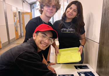 Happy students display their print material