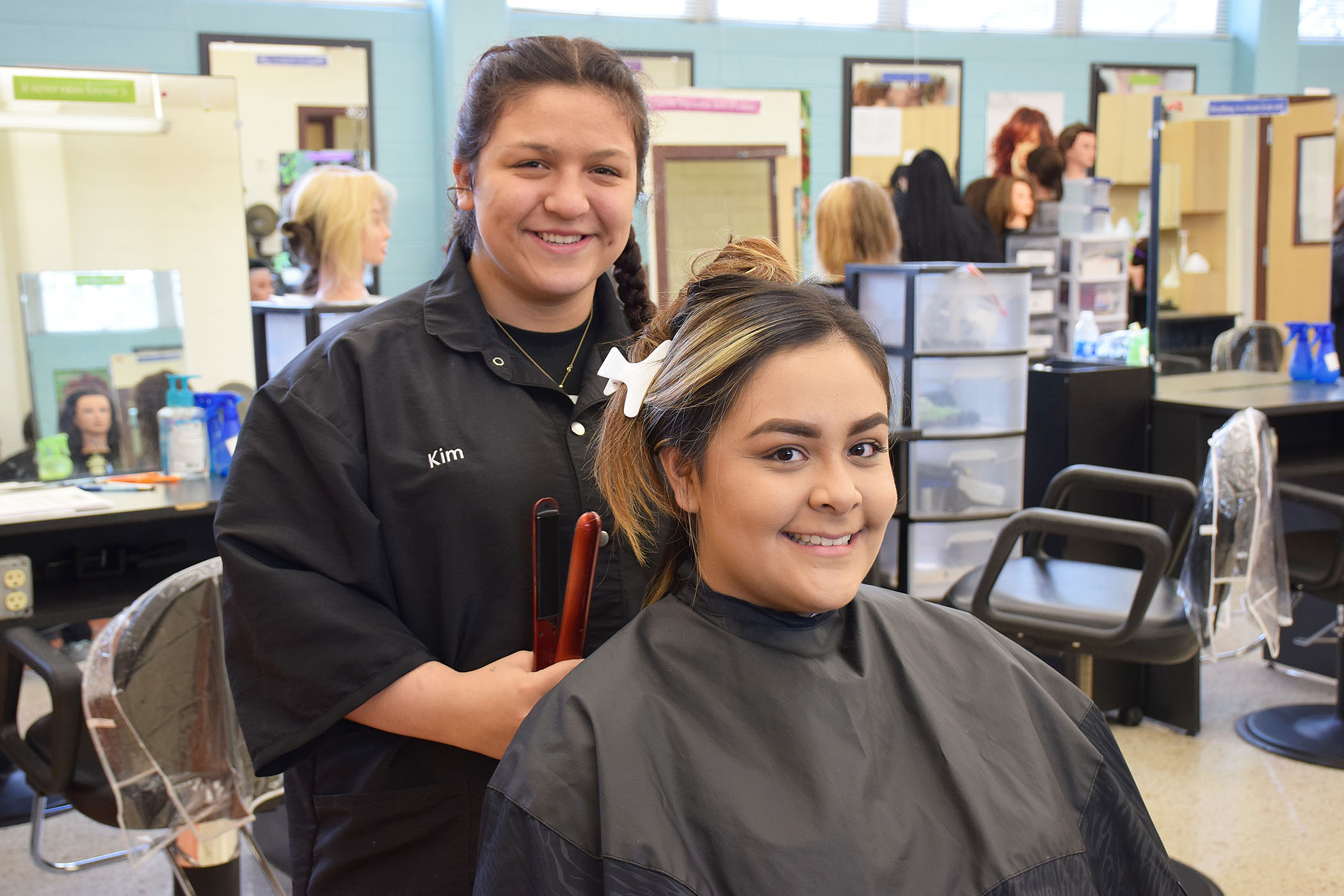 A student styles a woman's hair