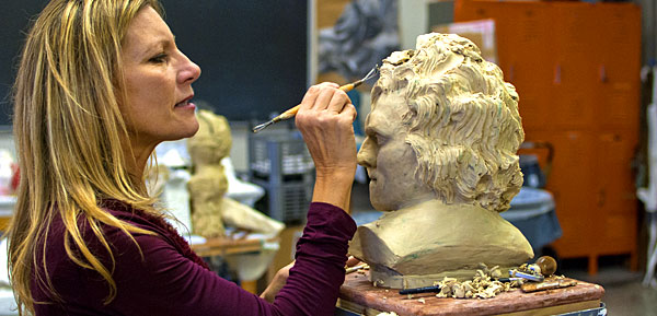An artist is adding up some finishing touches on her sculpture.