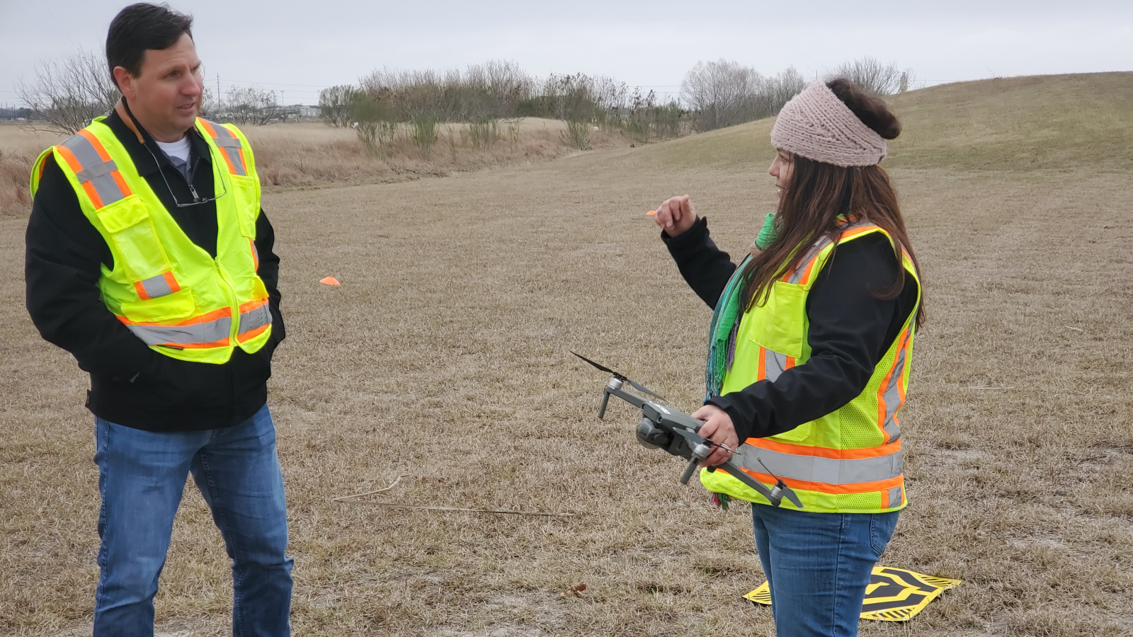 Two GIS students talking holding a drone.