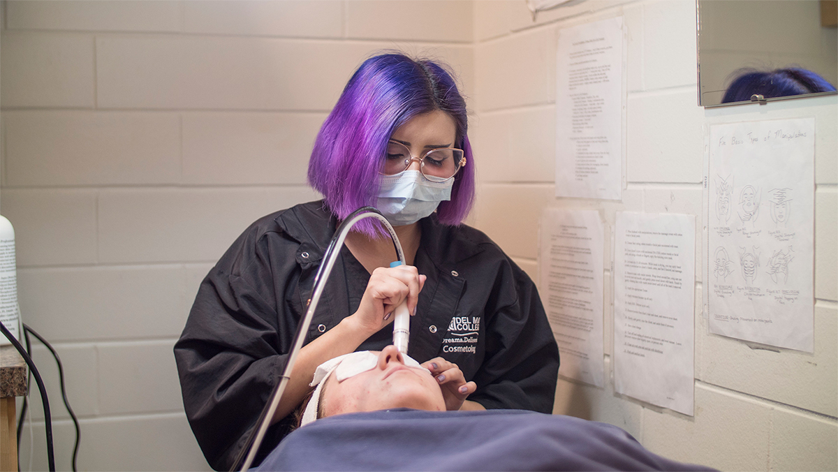 A student performs a microdermabrasion treatment on a woman