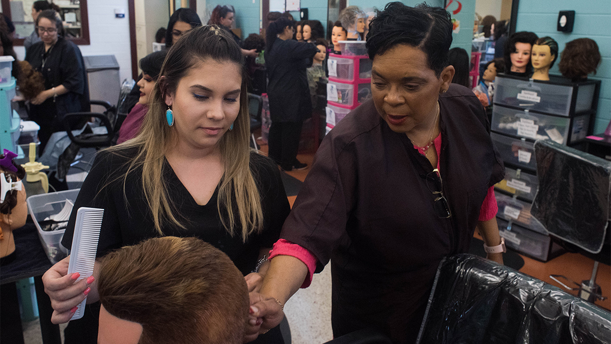 Cosmetology students work in a busy salon-like classroom