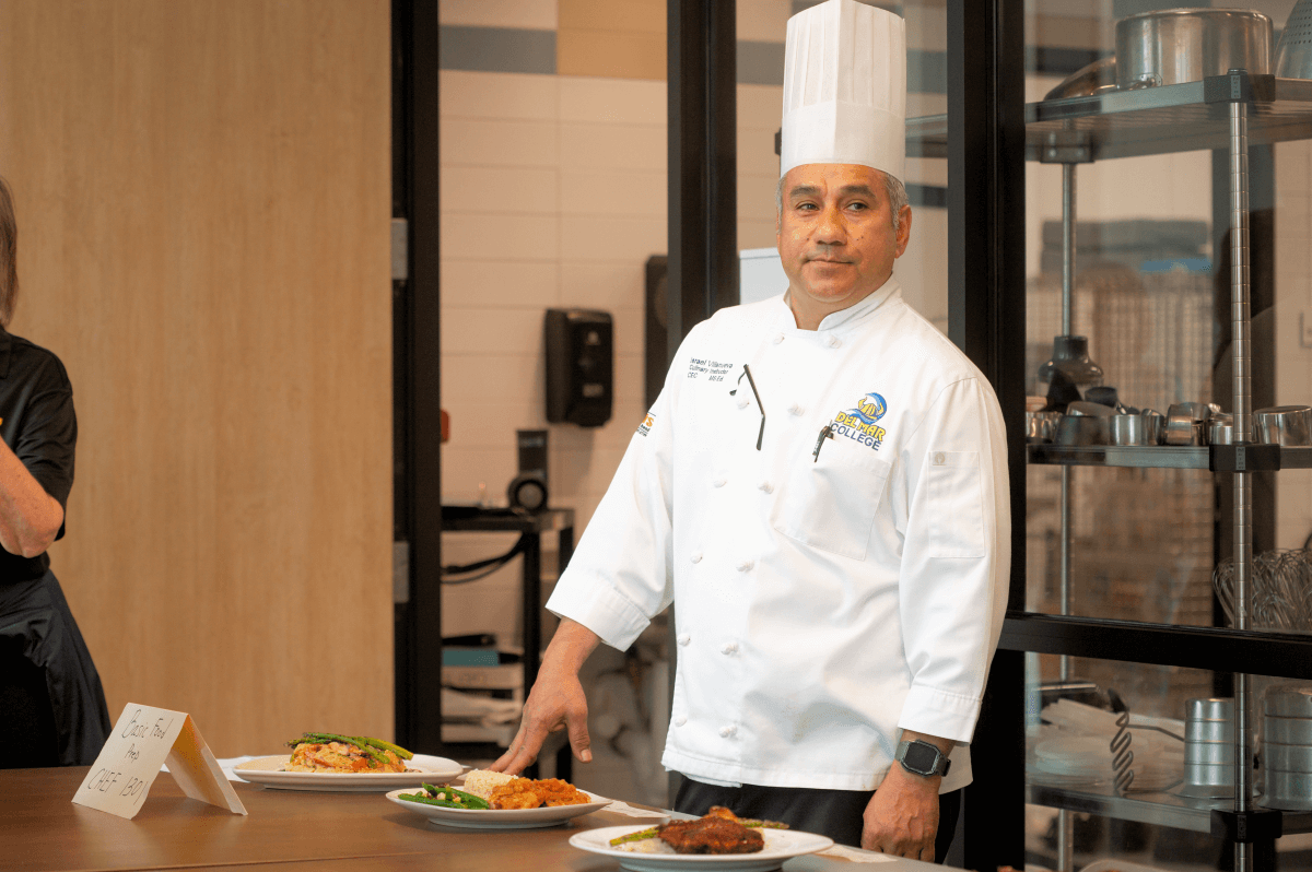 Chef Izzy serves food in front of one of the Del Mar kitchen classrooms