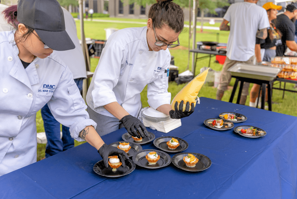 Student Chefs preparing pastries with a piping bag at an outdoor event at the Oso Creek Campus.