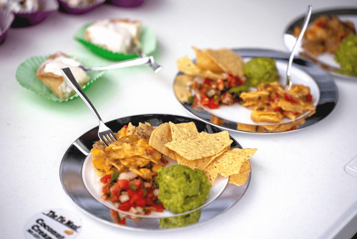 Plates of Mexican-inspired food with chips, guacamole, and salsa next to slices of pie.