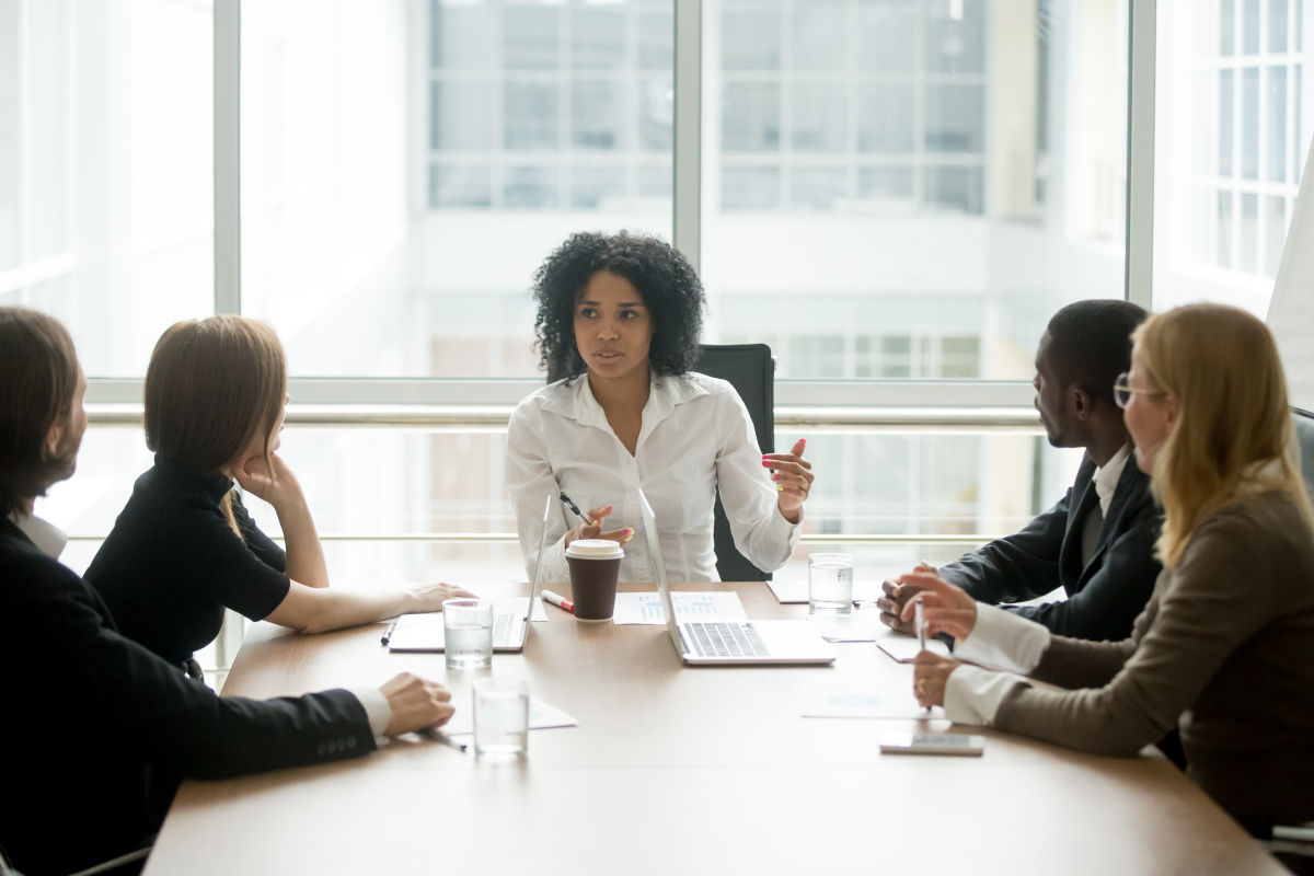 A business woman leads a discussion at a meeting of co-workers