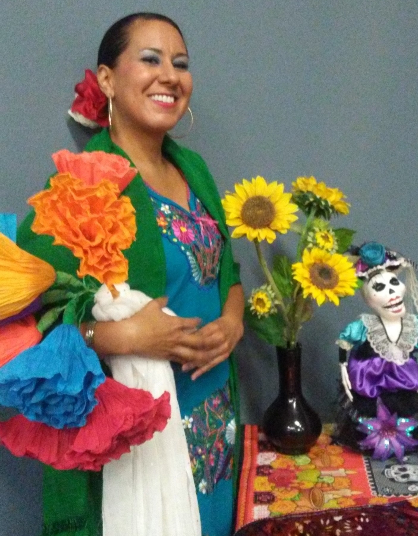 Teresa Saldivar, smiling, in her colorful folklorico dress.