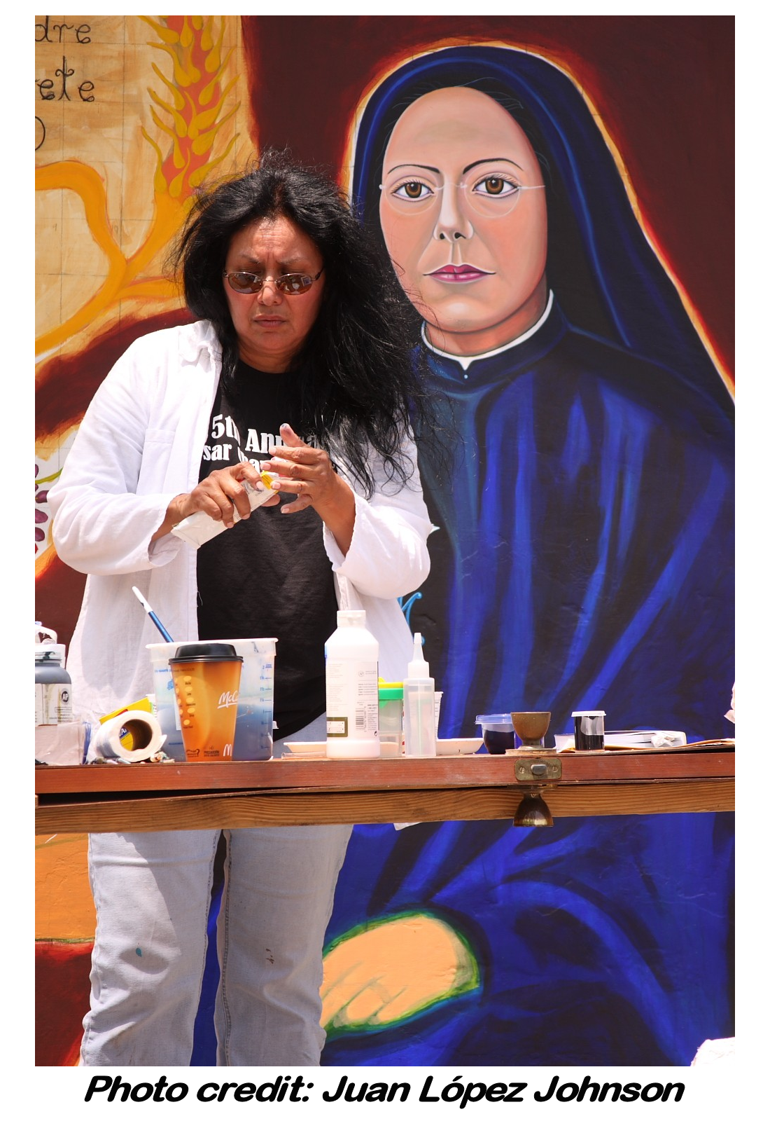 Santa Barraza in front of her artwork