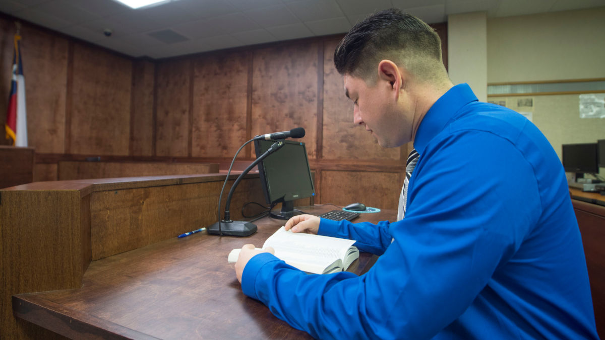 photo of a student and the defendant's desk in the courtroom part of the Del Mar College Captioning Lab