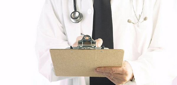 A doctor writes on a clipboard.