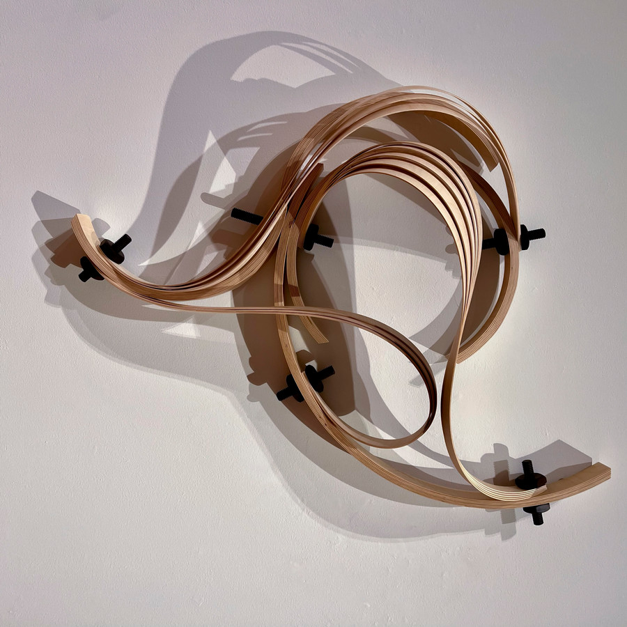 wall sculpture of wood bent in a swirling shape