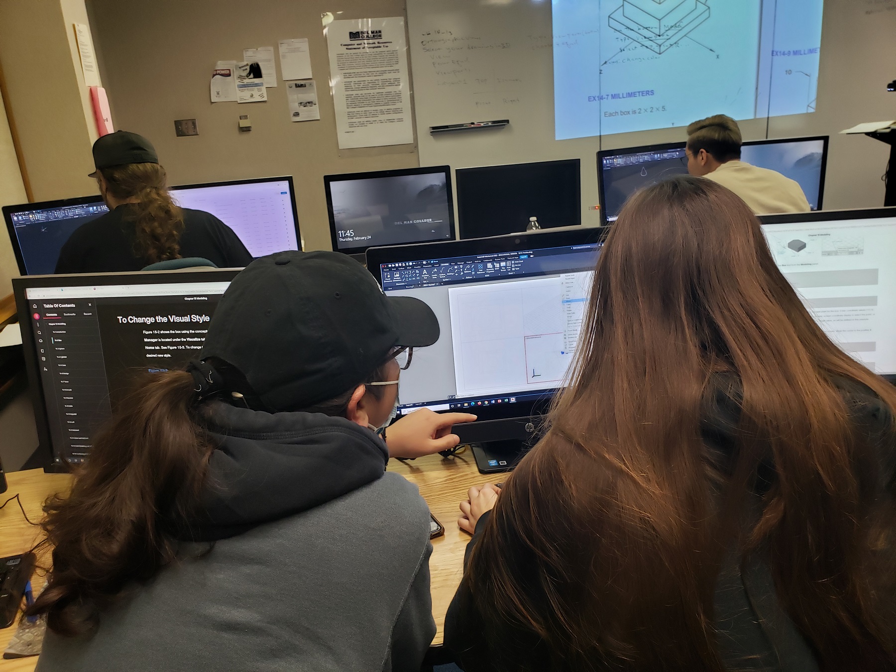Engineering students working on a computer together.