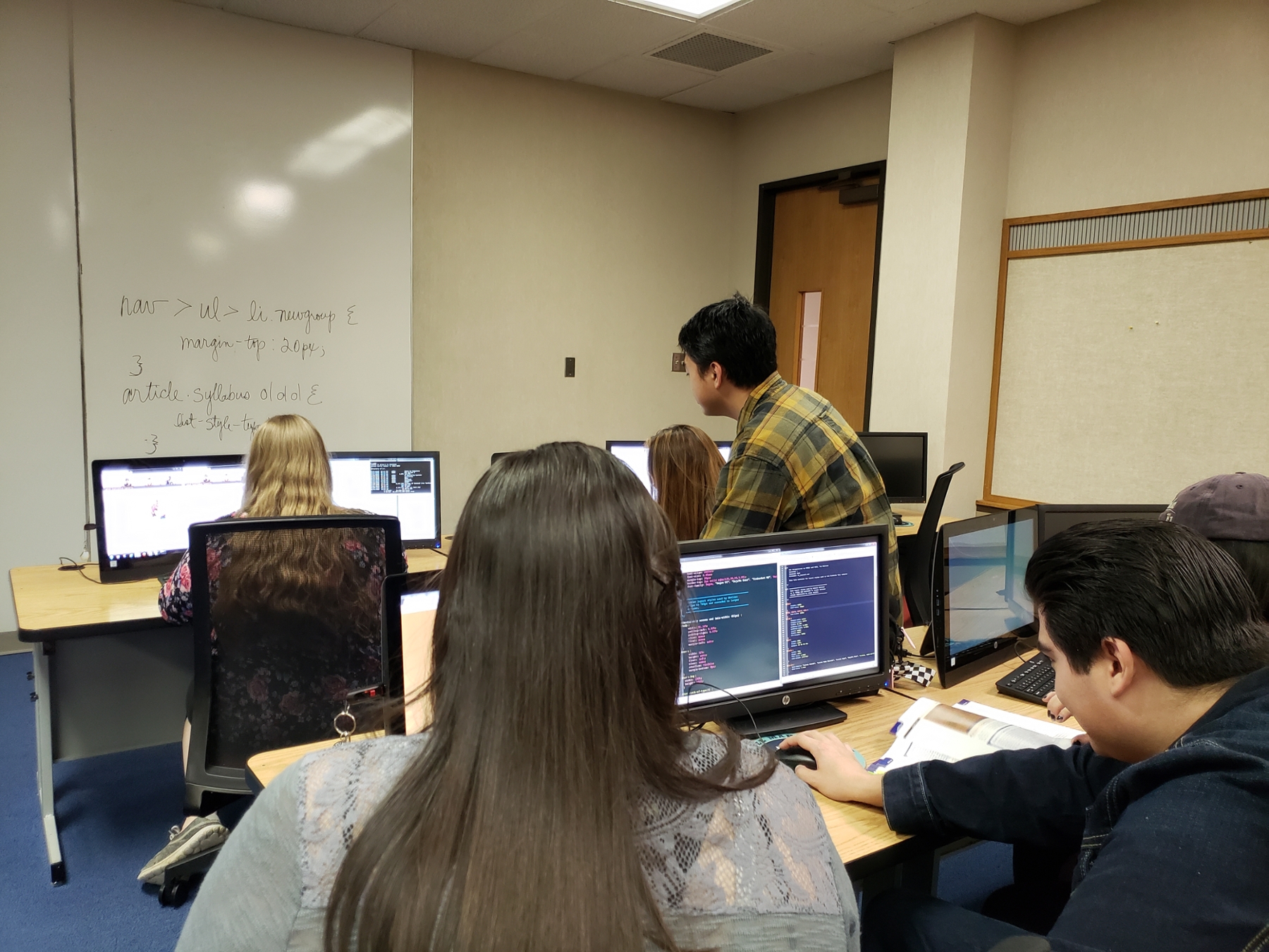 Students working in groups on computers.