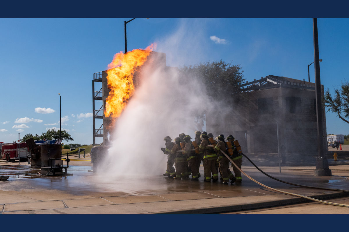 Firefighter students extinguishing a chemical fire for a demonstration
