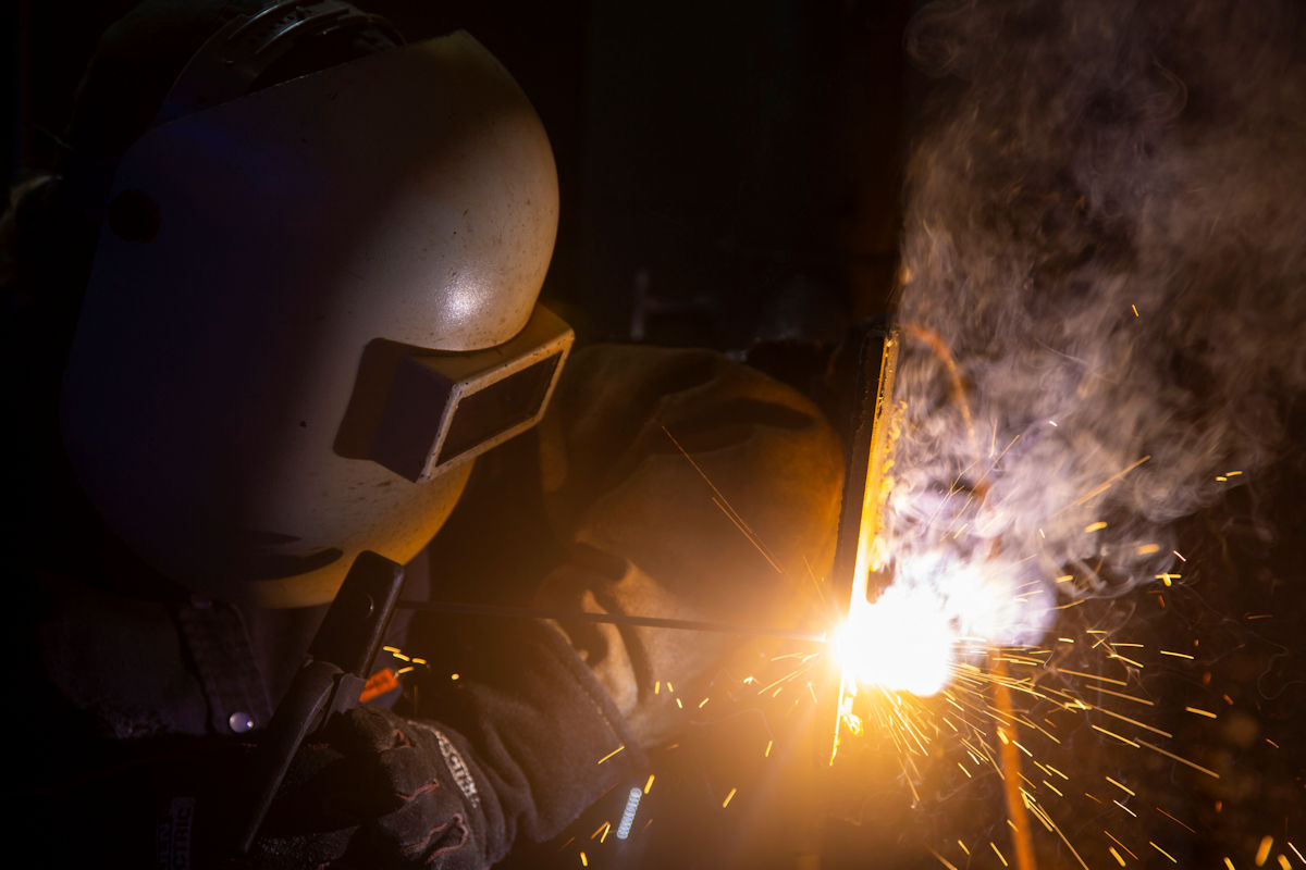 Female student welding a pipe
