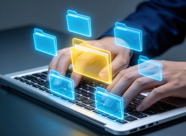Hands typing on a laptop with floating digital folder icons, one highlighted in yellow.