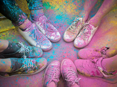 People's feet in a circle with colored powder all over them