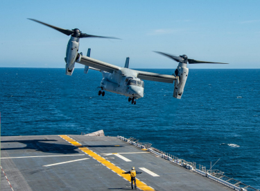 A military airplane landing on an aircraft carrier in the ocean