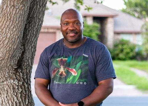 man standing next to a tree