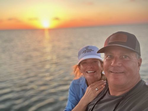 man and woman standing in front of body of water
