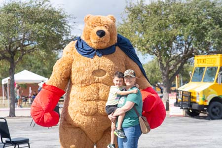 Viking Fest visitors posing with person in giant bear costume