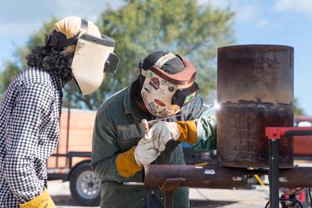 Welders competing in the Dia De Los Muertos welding competition